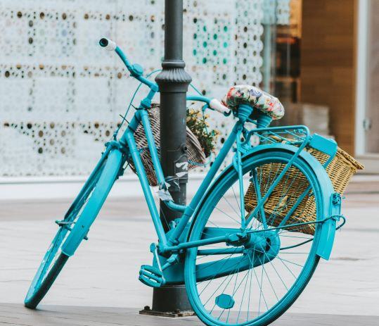 blue bike with basket colourful saddle