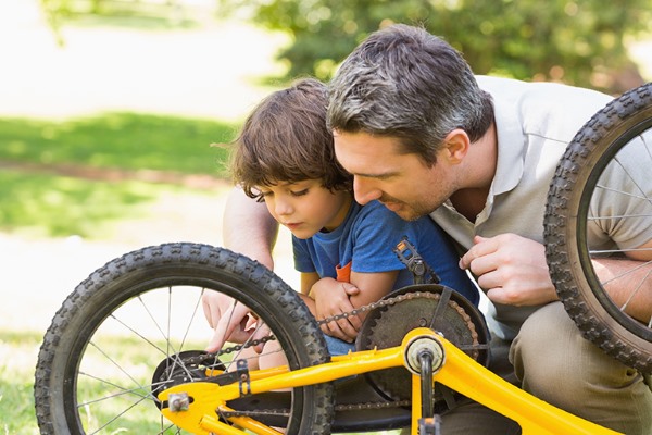 father help kid fixing bike check brakes safety tips