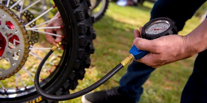 person hold tool check bike pressure