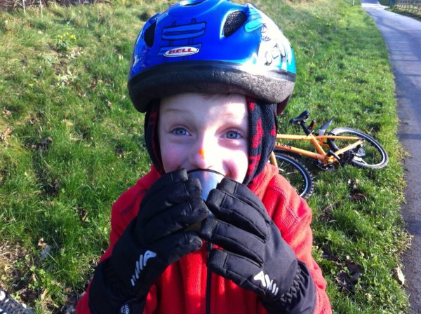 kid happy holding cup cycling gloves bike safety