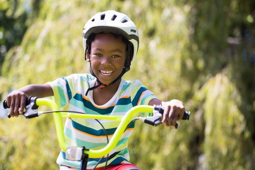 kid happy riding bike daytime helmet safety