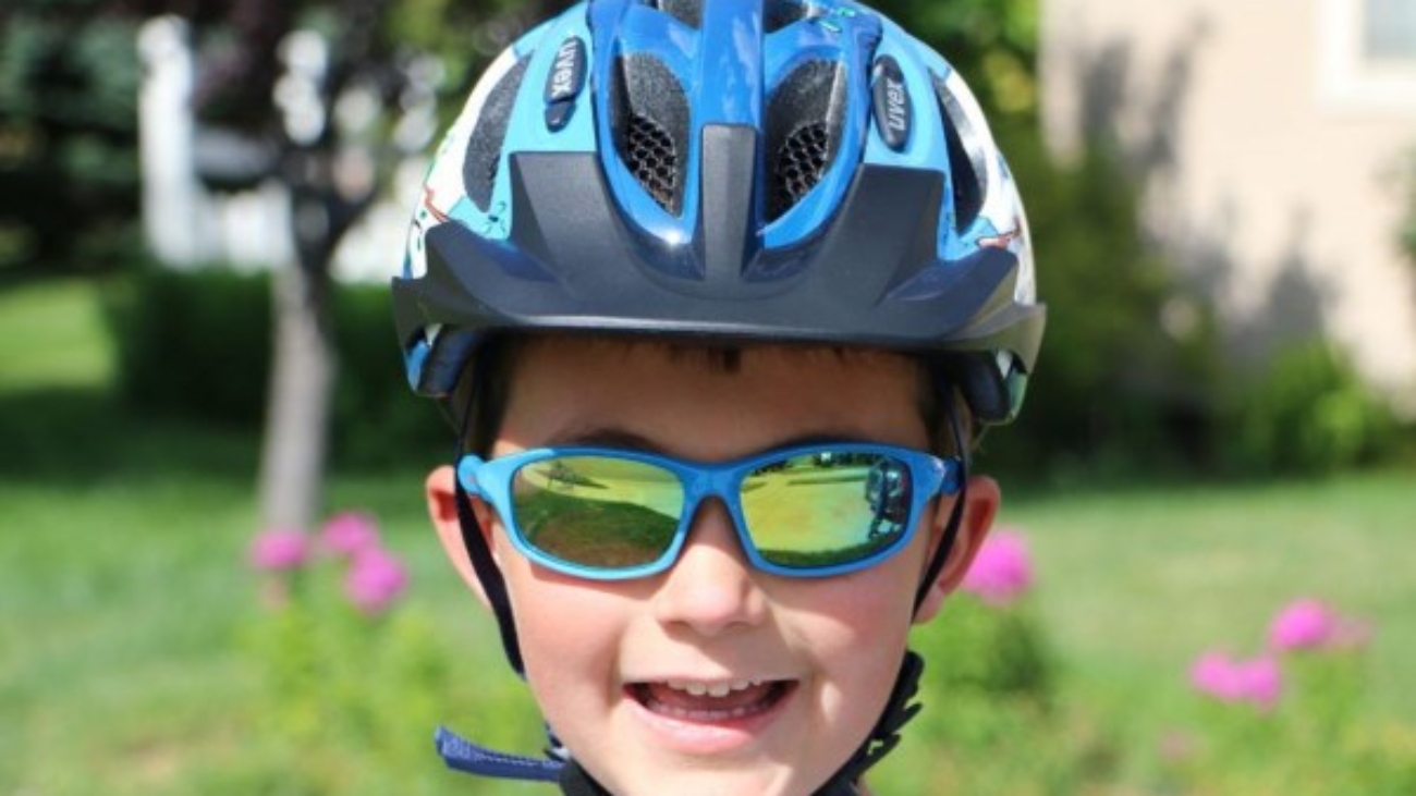 boy smiling at camera safety goggles cycling bike safety tips