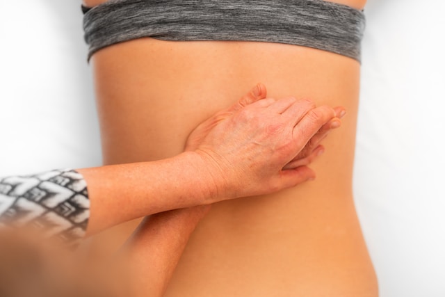 woman massage lower back pain cycling